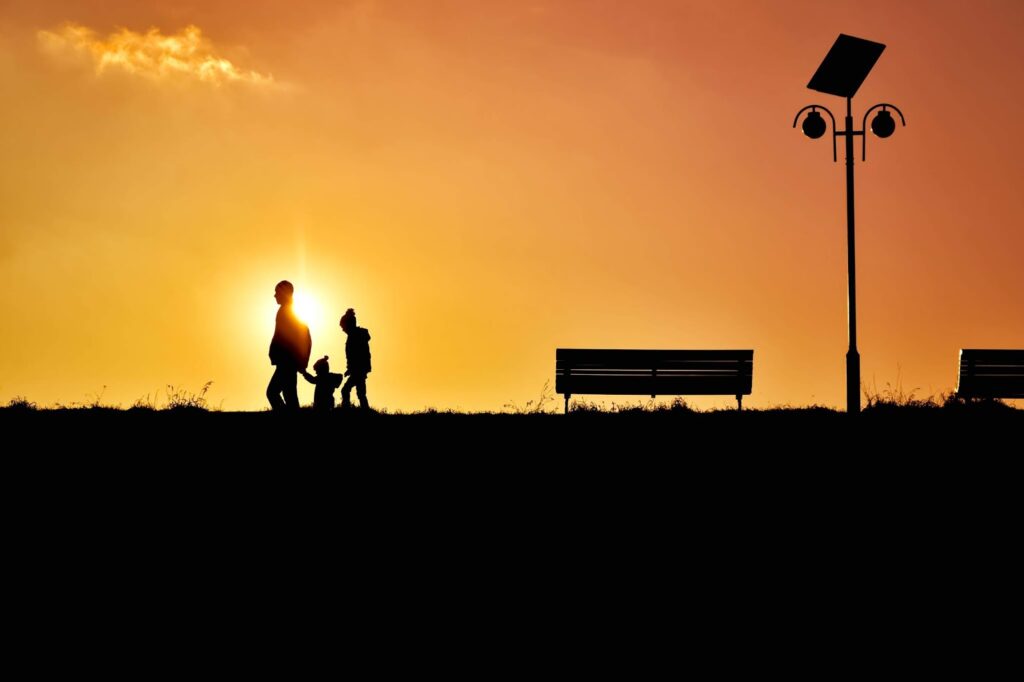 Sunset Silhouette A family walking past a orange sunset in silhouette.